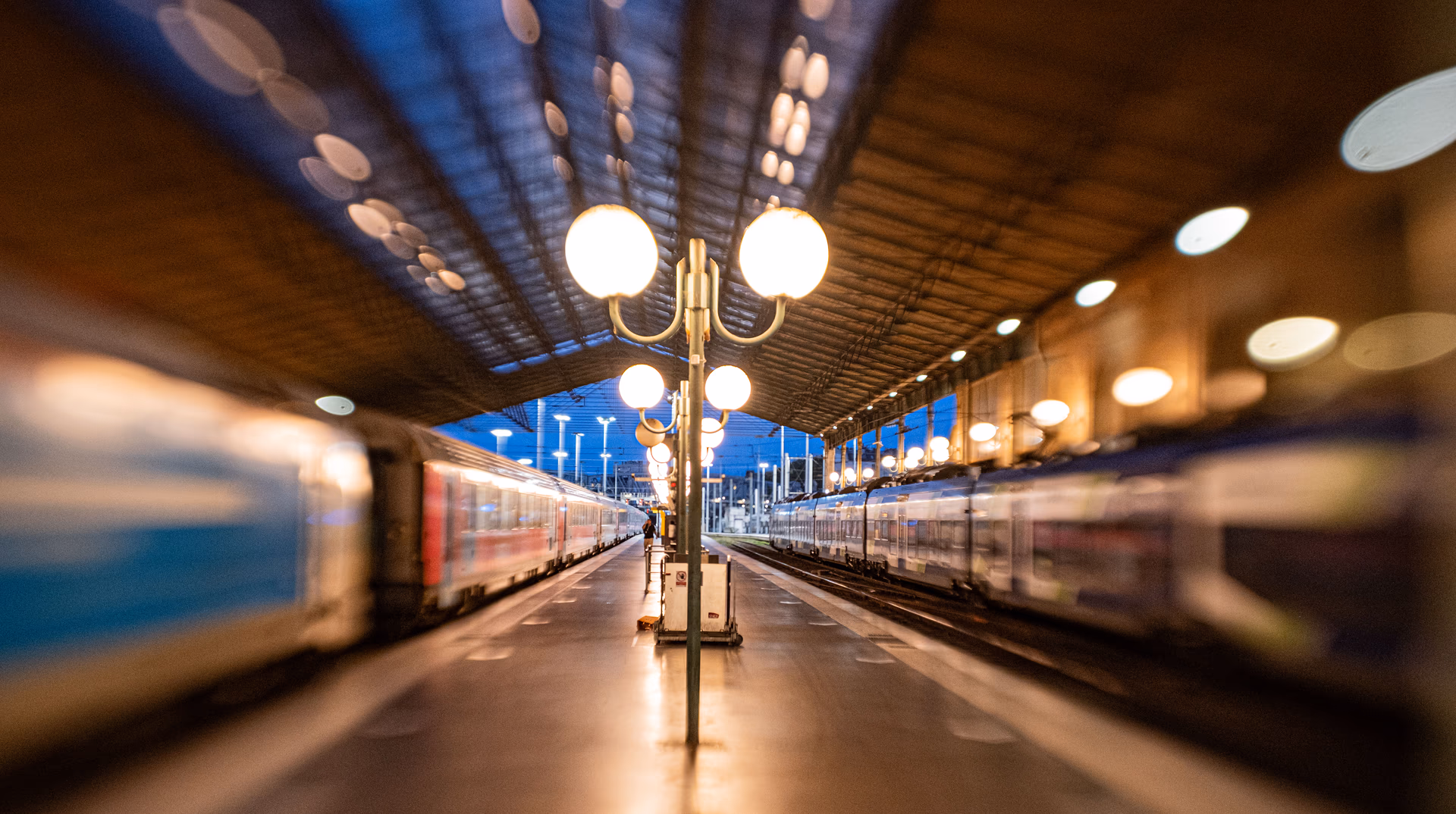 Leerer Bahnsteig mit Zügen und Straßenlaterne bei Dämmerung in Paris