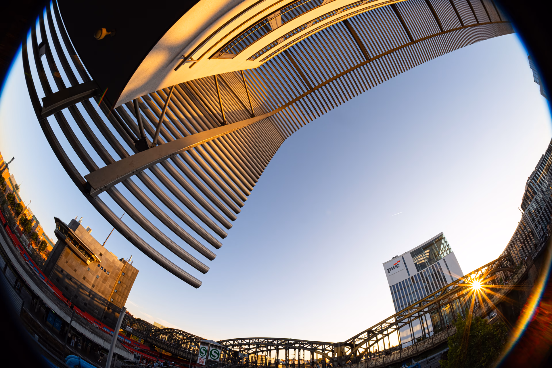 Fisheye-Aufnahme einer Brücke und moderner Gebäude bei Sonnenuntergang