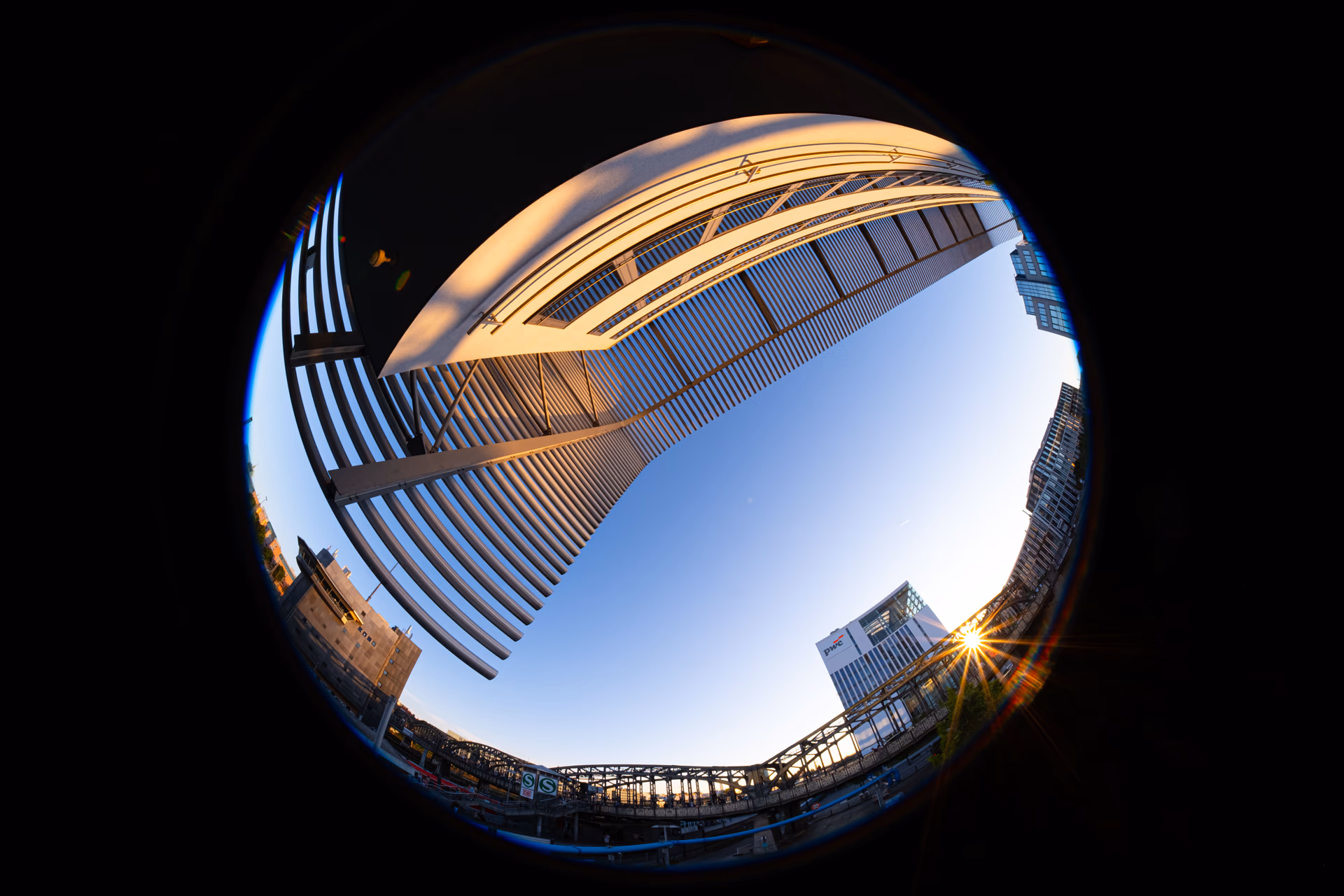 Fisheye-Aufnahme von München mit Brücke und modernen Gebäuden im Sonnenuntergang