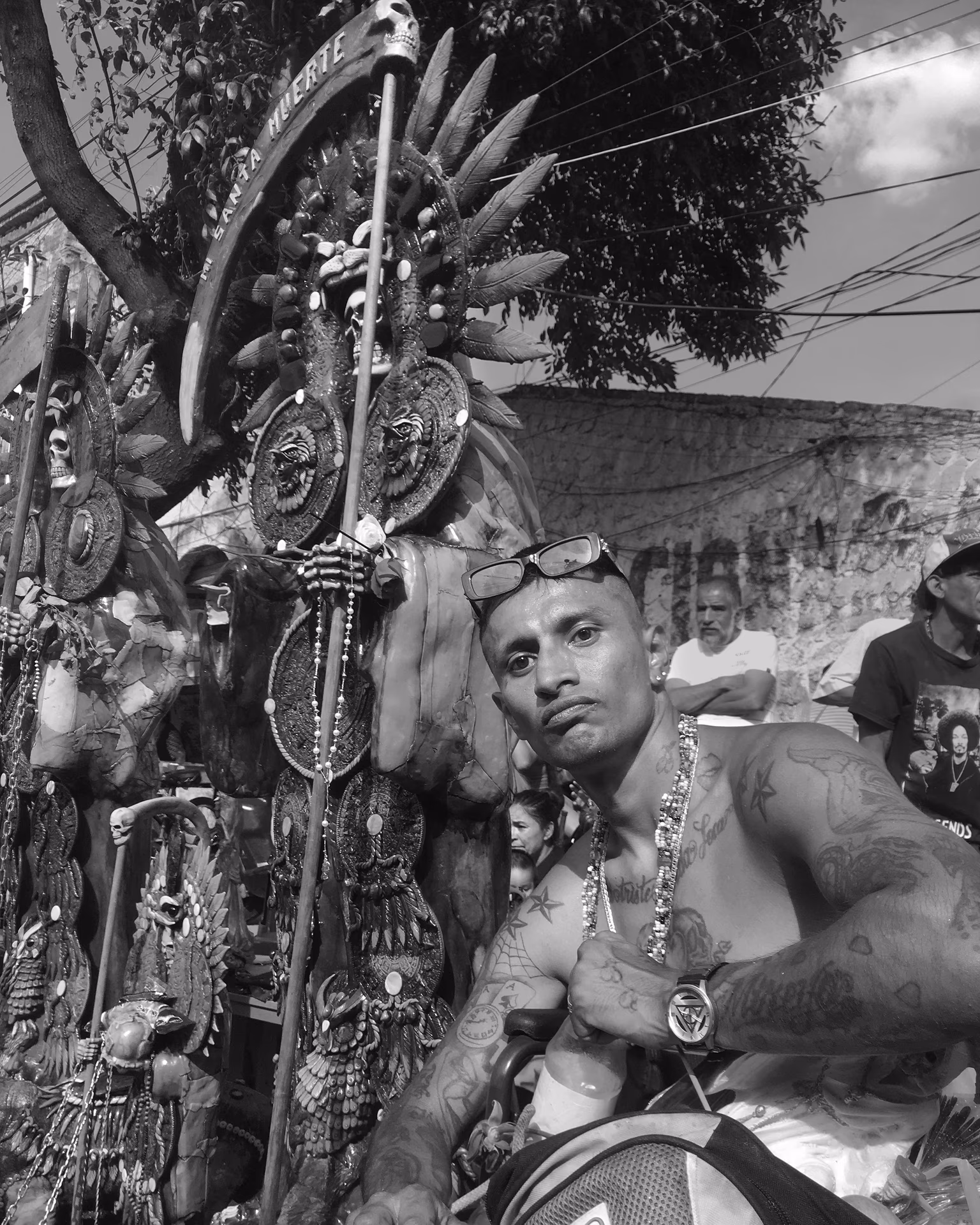 Mann mit Tattoos und Schmuck vor Santa Muerte Altar