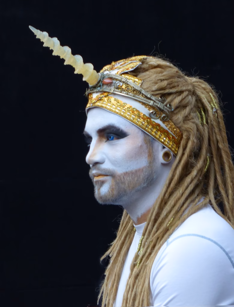 Mann mit weißem Gesicht, blauem Auge und Einhorn-Kopfschmuck