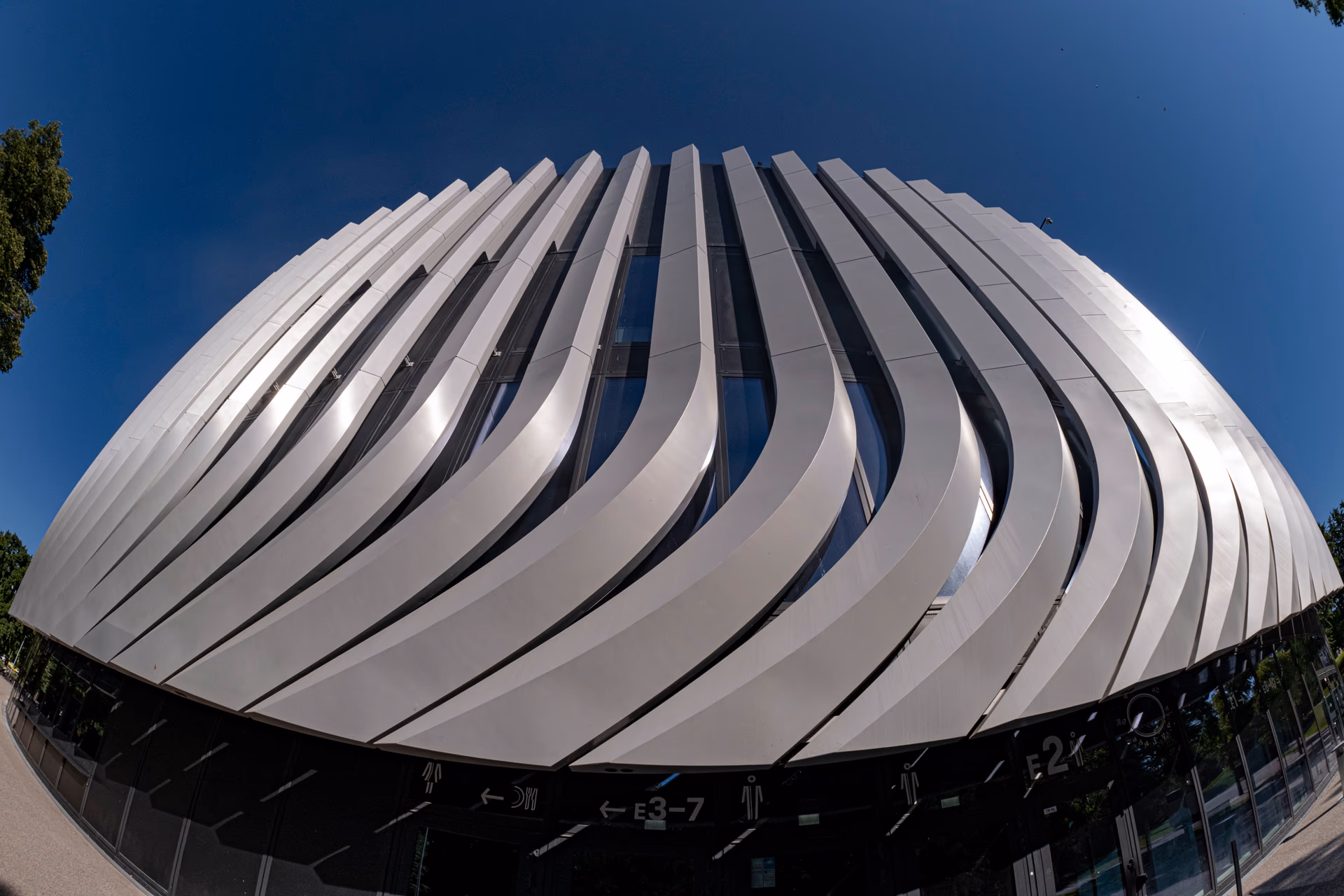 Moderne Architektur mit geschwungenen Fassadenelementen und blauem Himmel