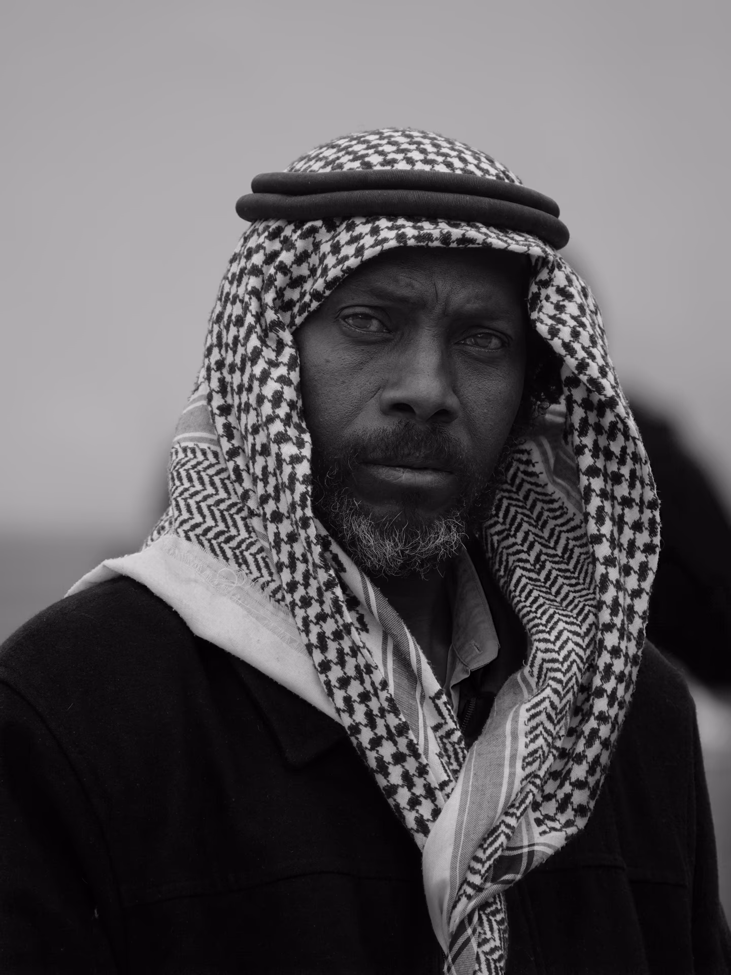 Porträt eines Mannes mit Keffiyeh und Bart, ernster Blick